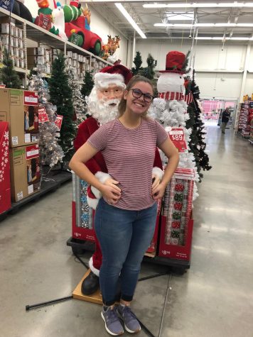 Sophomore Della Fowler "prom poses" with a Santa figure while Black Friday shopping. 