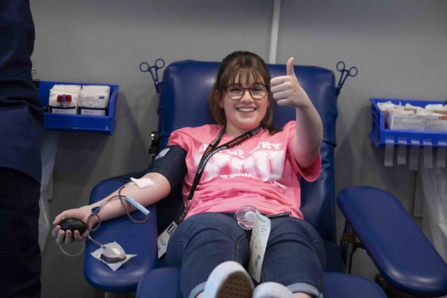Junior Evelyn Spiser gives a thumbs up while donating blood.