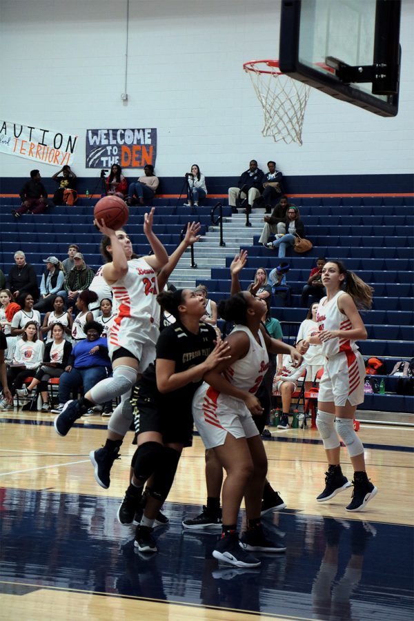 Sophomore Jessica Lynn jumps over her opponents to go for a basket.