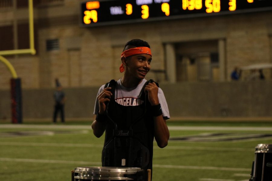 Junior Michael Garcia smiles over at his teammates on drumline.