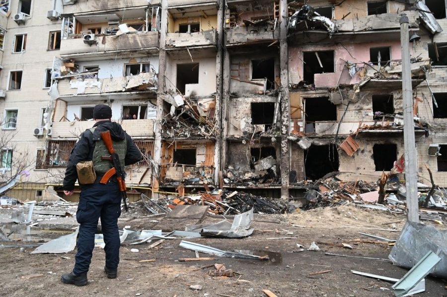 A Ukrainian officer standing by a destroyed building in Kyiv, Ukraine.